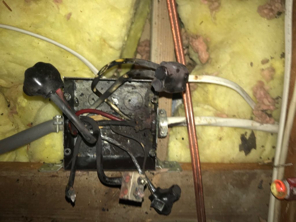 Burned residential electrical junction-box connection documented by Dollens Electric.